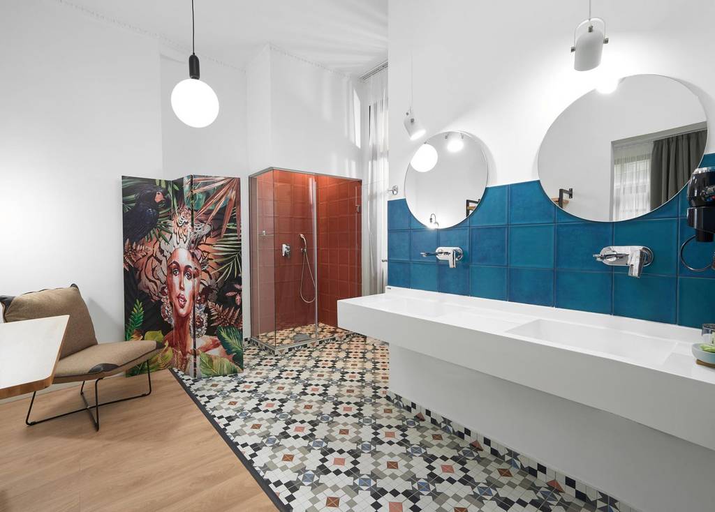 Twin-mirror vanity with teal tiles and jungle shower screen