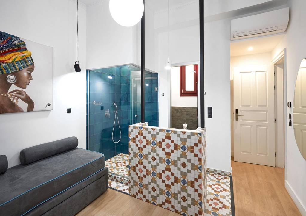 Bagno con lavabo su pilastro a mosaico e doccia petrolio