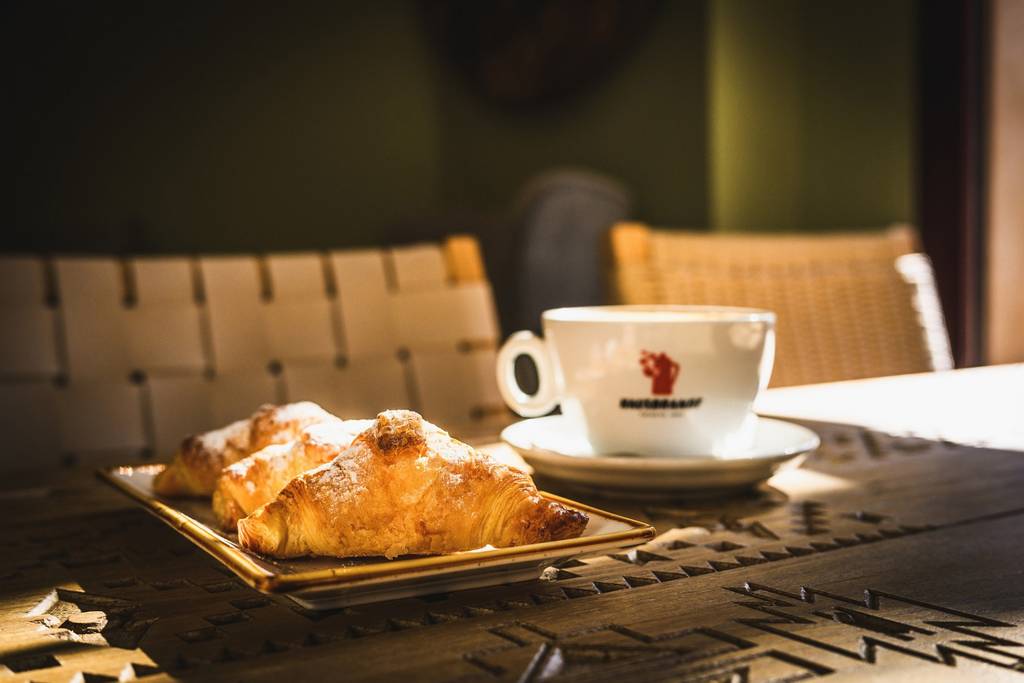 Croissants and cappuccino served on a rustic wood table