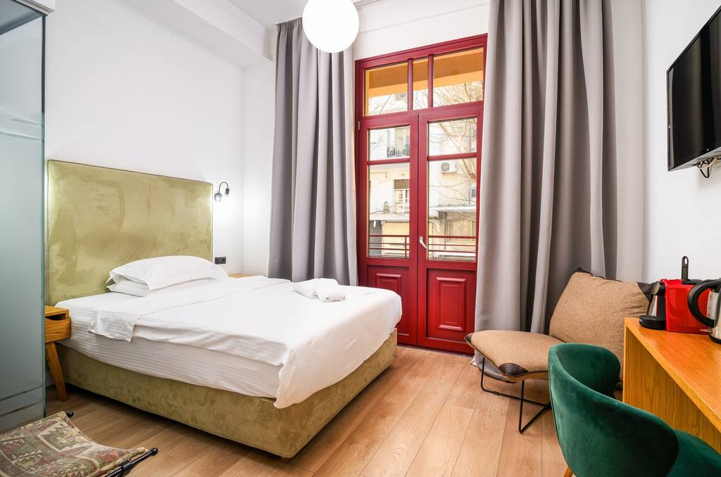 Bedroom with olive headboard and red coffee machine