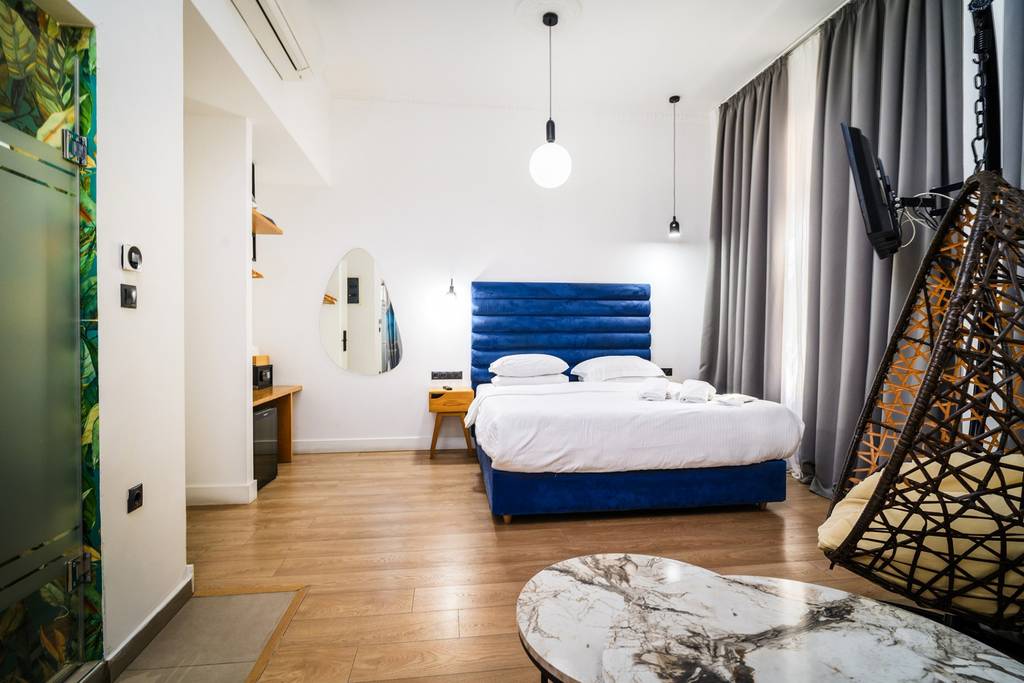 Suite bedroom with hanging rattan chair and mural door